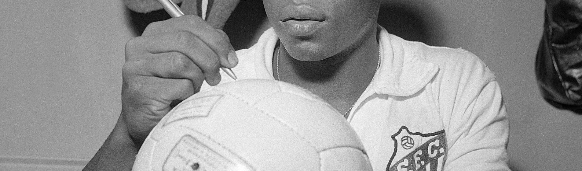 Photo de Pelé dédicaçant un ballon de football